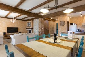 een eetkamer en woonkamer met een tafel en stoelen bij Luxury Villa Maša in Dobrinj