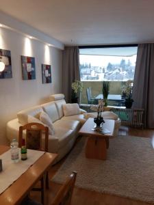 a living room with a white couch and a table at Apartmenthotel Hohegeiß Kasing MIT FREIEM WLAN und Schwimmbad in Hohegeiß