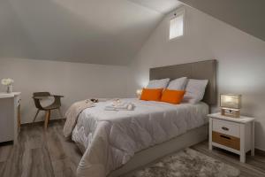 ein Schlafzimmer mit einem großen Bett mit orangefarbenen Kissen in der Unterkunft Casa Tiana in Ponta do Sol