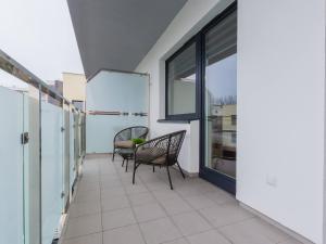 a balcony with two chairs and a table at VacationClub – Bliżej Morza Apartament 98 in Kołobrzeg