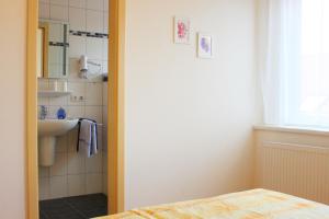 a bathroom with a sink and a bed in a room at Meeresblick Fehmarn in Fehmarn +39 photos