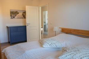 ein Schlafzimmer mit einem Bett mit einer blauen Kommode und einem Bett mit einem sidx sidx sidx in der Unterkunft Ferienwohnung Strandspass (14) - mit Saunabereich in Timmendorfer Strand