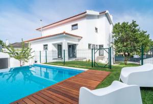 a villa with a swimming pool in front of a house at Casa em Cascais in Cascais