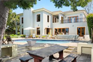 Casa blanca grande con piscina y mesa en Thomson's Accommodation, en Ciudad del Cabo