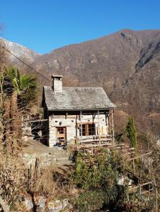 een oud huis aan de kant van een berg bij Casa Larice in Mergoscia