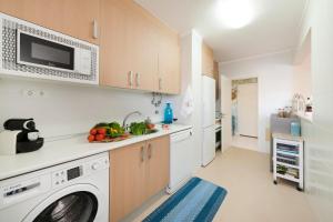 uma cozinha com uma máquina de lavar roupa e um lavatório em Dream's House em Portimão