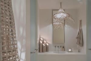 a bathroom with a sink with a mirror and a chandelier at Raya Heritage - SHA Plus in Chiang Mai