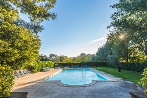 una piscina en un patio con sillas y árboles en La Locanda Della Chiocciola, en Orte