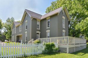 een huis met een wit hek bij Prairie Guest House in Fishers