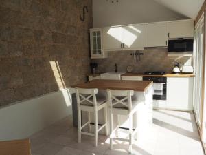 een keuken met een houten tafel en witte kasten bij Old Stables in Pulborough
