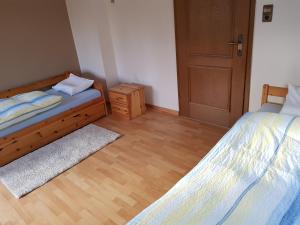 1 dormitorio con 2 camas y suelo de madera en Gästehaus Hein en Emsbüren