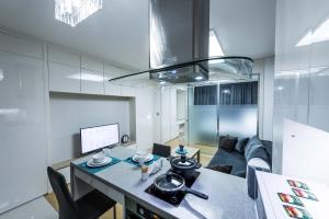 een keuken en een woonkamer met een tafel en een bank bij THEADDRESS HIGHVILL Lux in Astana