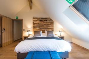 um quarto com uma cama grande num sótão em Koru Hôtel & Private Wellness em Autre-Église