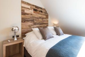 um quarto com uma cama e uma parede de madeira em Koru Hôtel & Private Wellness em Autre-Église