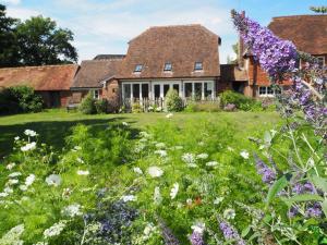 a garden with flowers in front of a house at Old Stables in Pulborough