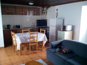 a kitchen with a table and a blue couch at TINA - 3C - Alojamento Local -RRAL 1048 in Álamos Bravos