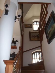 a staircase in a house with paintings on the walls at Sóvirág Vendégház in Hortobágy