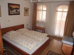 um quarto com uma cama num quarto com janelas em Sóvirág Vendégház em Hortobágy