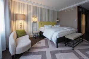a bedroom with a large bed and a chair at Insel-Hotel Heilbronn in Heilbronn