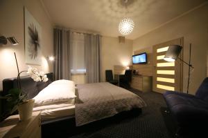 pokój hotelowy z łóżkiem i kanapą w obiekcie Hotel Seven 7 w Kaliszu