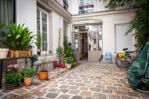 um pátio com vasos de plantas e um edifício em Artisan Lofts courtyard Opéra em Paris