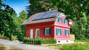 a red house with solar panels on the roof at Erwins Ferien-Paradies in Hörbranz