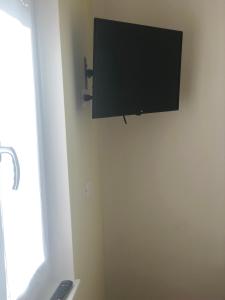 telewizor z płaskim ekranem na ścianie pokoju w obiekcie VILLA ZAIRA w mieście Il Cristo