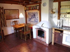 a kitchen with a fireplace and a table in it at Madeira-Meerblick-Haus in Estreito da Calheta