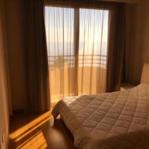 a bedroom with a bed and a large window at Sea View Central Apt Ithaki in Larnaca