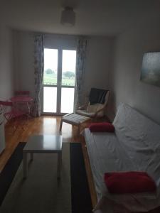 Sala de estar con cama, silla y mesa en Apartamento Rio Lavilla, en Castañares de Rioja