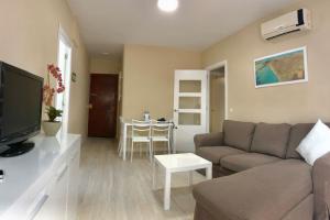sala de estar con sofá y mesa en El piso de la Calzada, en Sanlúcar de Barrameda