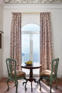 una stanza con un tavolo e due sedie e una finestra di Villa Margherita by Belmond a Ravello