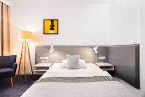 ein Schlafzimmer mit einem großen Bett und einem Stuhl in der Unterkunft Hotel Restaurant Höldrichsmühle in Hinterbrühl