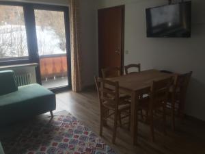 ein Esszimmer mit einem Tisch, Stühlen und einem TV in der Unterkunft Gästehaus Wagner in Grainau
