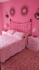 a pink bedroom with a bed and two mirrors at Apartamento Marín El Campello in El Campello