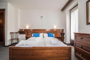 um quarto com uma grande cama de madeira com almofadas azuis em Locanda ai Dogi em Pieve di Cadore