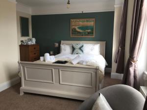 um quarto com uma cama branca e uma parede verde em The Alendale Guesthouse em Weymouth