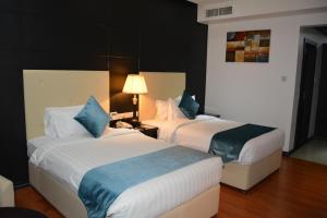 Un pat sau paturi într-o cameră la The Olive Hotel, Juffair