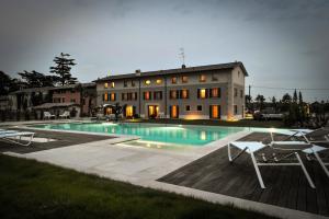 a house with a swimming pool in front of a building at Belvivere Suites in Sona