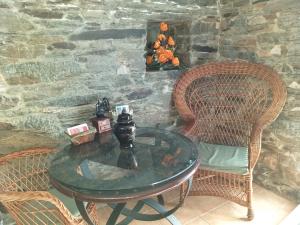 una mesa, 2 sillas y una pared de piedra en Casa Quiroga, en Lamas