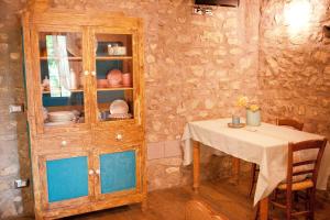 ein Esszimmer mit einem Tisch und einem Holzschrank in der Unterkunft Il Pievano B&B in Campiglia Marittima