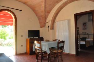 uma sala de jantar com uma mesa com cadeiras e uma televisão em Agriturismo Soiano Famiglia Rolfini em Montaione