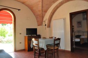 a dining room with a table with chairs and a tv at Agriturismo Soiano Famiglia Rolfini in Montaione