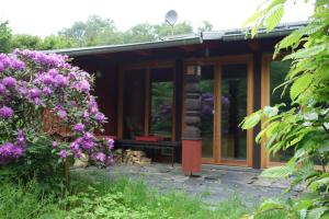 una casa con flores púrpuras delante de ella en Waldhaus Allrode, en Allrode