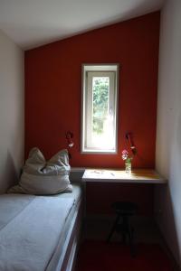 Habitación roja con cama y ventana en Waldhaus Allrode, en Allrode