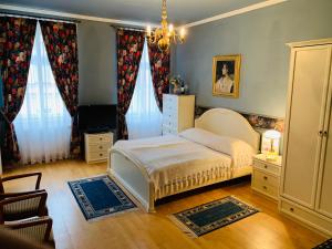 - une chambre avec un lit et un lustre dans l'établissement Pension Šejko, à Horní Planá