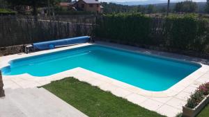 a swimming pool in a yard with a fence at Alojamiento Turistico La Dehesa in Las Navas del Marqués