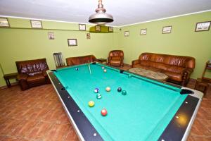 a pool table in a living room with leather furniture at Apartments ADMIRAL NELSON in Hel