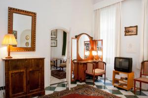 布達佩斯的住宿－匈牙利紀念酒店，一间带镜子和电视的客厅