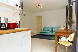 a kitchen and living room with a table and a blue couch at Raja Jooseppi Apartments - Spittelmarkt Historische Mitte in Berlin